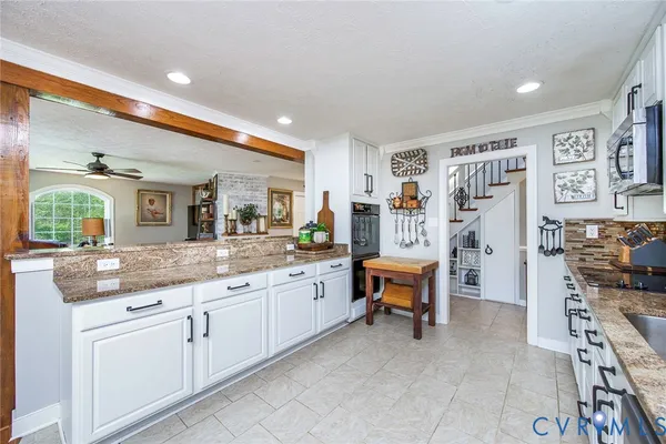 a kitchen with granite countertop a stove and cabinets