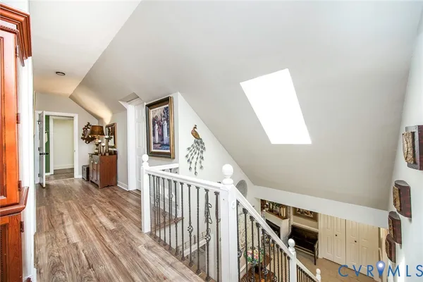 a bedroom with a flat screen tv on dresser and a chandelier