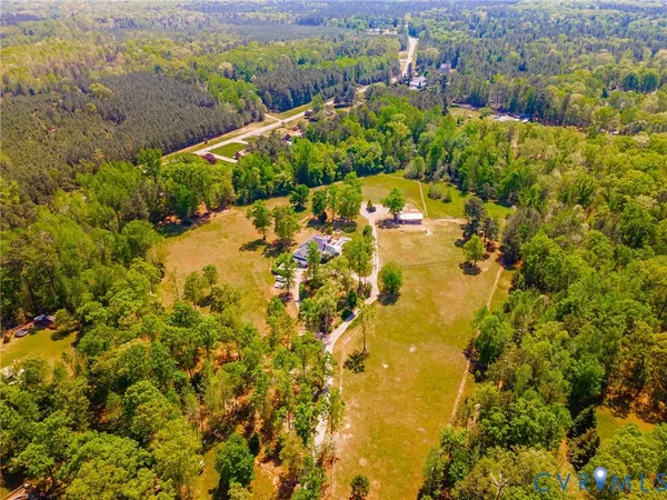 an aerial view of a house with a yard and lake view
