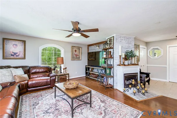 a living room with furniture a fireplace and a window