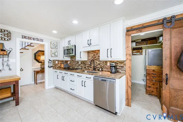 a kitchen with granite countertop a refrigerator and a sink