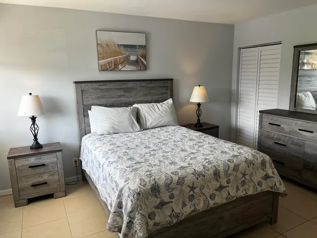 a bedroom with a bed and a lamp on dresser