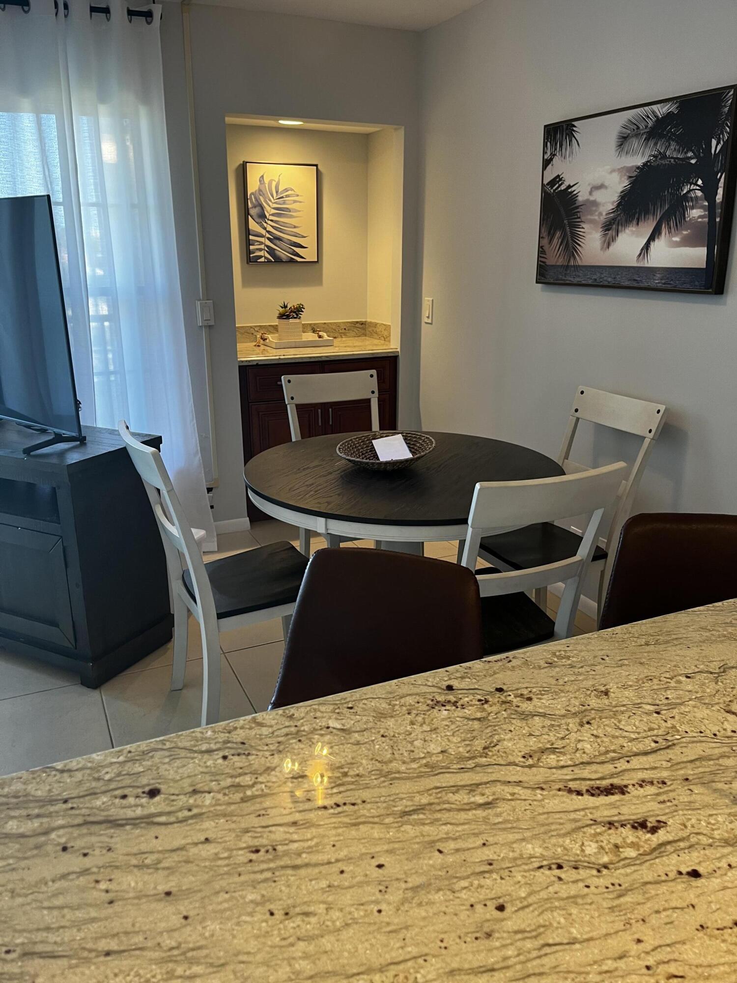 1605 Highway 1, Unit 203 V4 Jupiter, FL 33477 - Photo 8 of 33 a bedroom with a bed and a chandelier