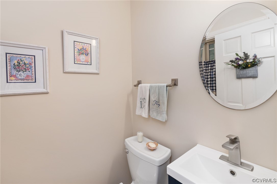 2730 West Brigstock Road Midlothian, VA 23113 - Photo 23 of 49 a bathroom with a toilet a sink and mirror