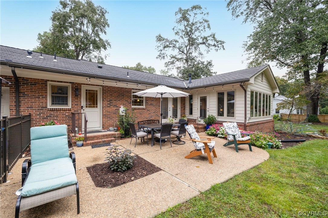 2730 West Brigstock Road Midlothian, VA 23113 - Photo 34 of 49 a view of a patio with couches table and chairs under an umbrella