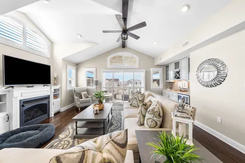a living room with furniture a flat screen tv and a fireplace