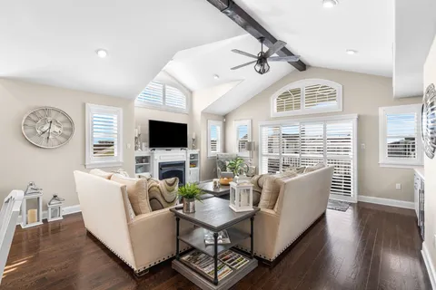 a living room with furniture a large window and a flat screen tv