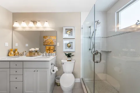 a bathroom with a sink a toilet and shower