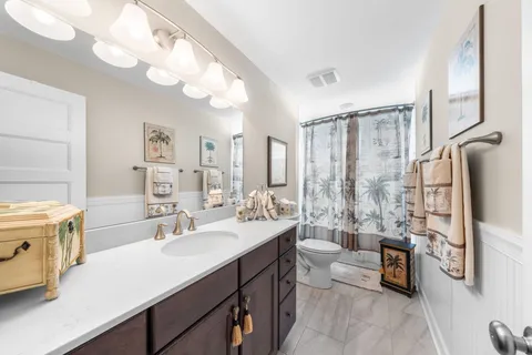 a en suite bathroom with double vanity a sink and a large mirror