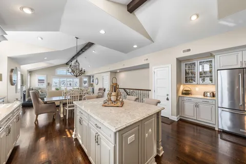 a kitchen with a refrigerator a stove and white cabinets with wooden floor