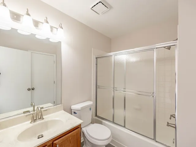 a bathroom with a sink vanity mirror and toilet