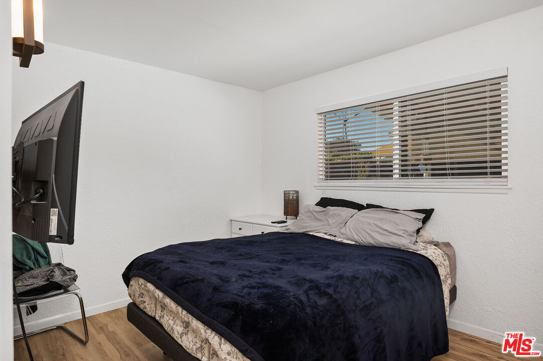 1397 Sycamore Drive Simi Valley, CA 93065 - Photo 11 of 20 a bedroom with a bed and wooden floor