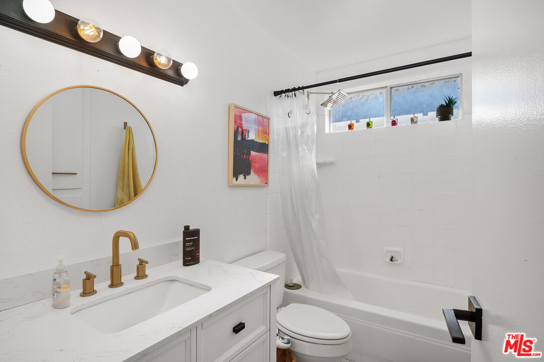 1397 Sycamore Drive Simi Valley, CA 93065 - Photo 16 of 20 a bathroom with a sink a toilet and a mirror