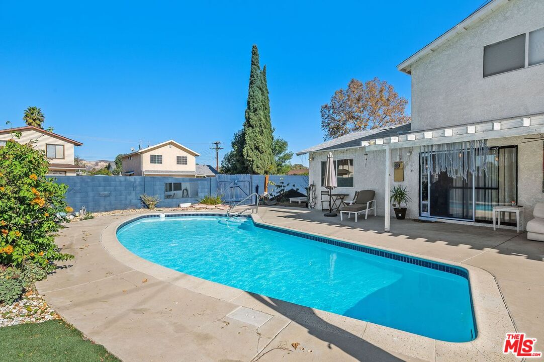 1397 Sycamore Drive Simi Valley, CA 93065 - Photo 18 of 20 a view of swimming pool with outdoor seating and house in the background
