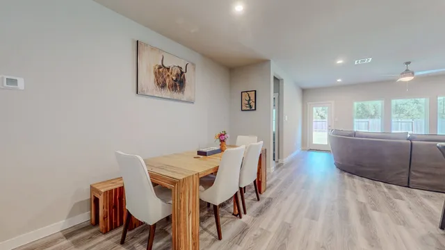 a kitchen with kitchen island granite countertop wooden floors and white cabinets
