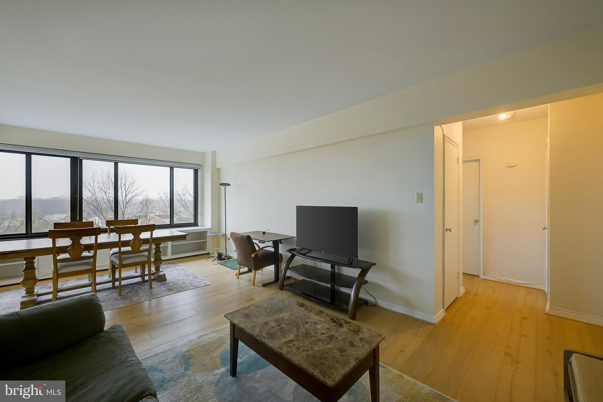 3601 Wisconsin Avenue Northwest, Unit 504 Washington, DC 20016 - Photo 12 of 23 a living room with furniture and a floor to ceiling window