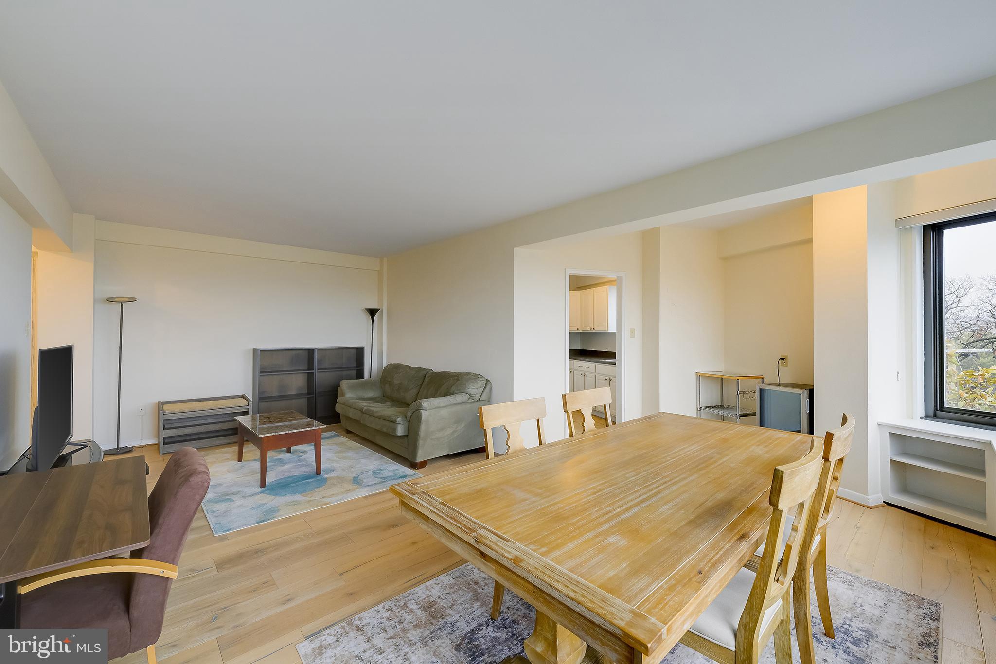 3601 Wisconsin Avenue Northwest, Unit 504 Washington, DC 20016 - Photo 7 of 23 a living room with furniture a flat screen tv and a refrigerator