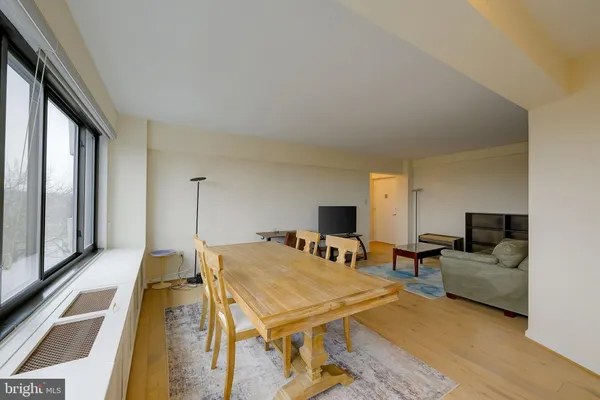 a dining room with furniture and a floor to ceiling window