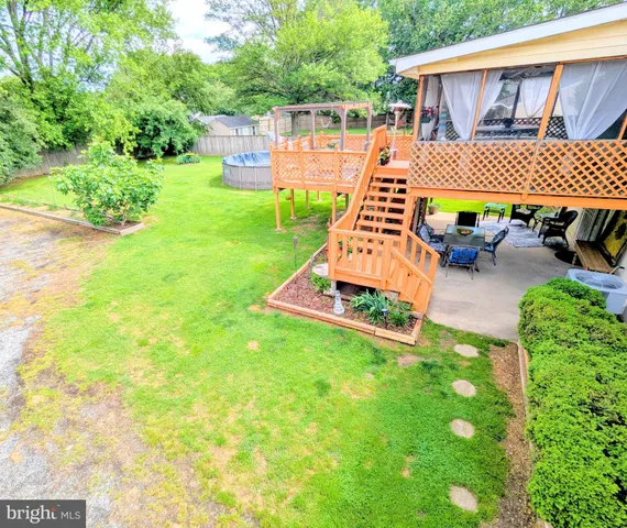 a view of a backyard with table and chairs potted plants and wooden fence
