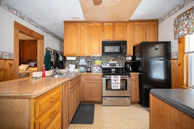 a kitchen with stainless steel appliances granite countertop a refrigerator stove microwave and sink