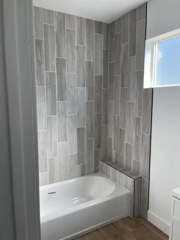 a white bath tub sitting next to a white cabinet