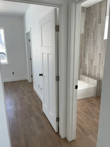 an empty room with wooden floor and mirror