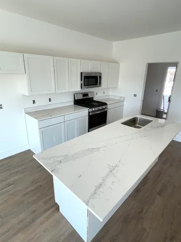 a kitchen with stainless steel appliances kitchen island sink refrigerator and stove
