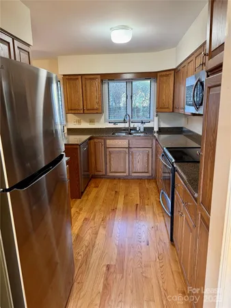 a kitchen with stainless steel appliances granite countertop a refrigerator and a stove