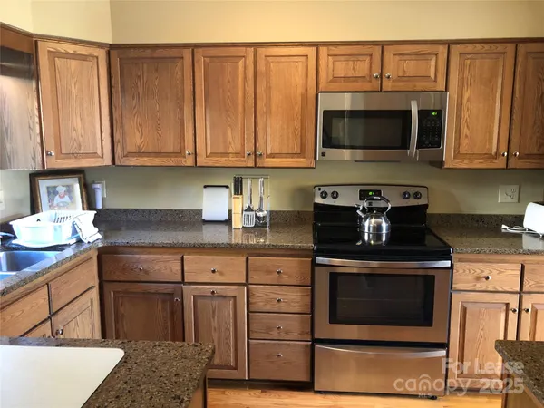 a kitchen with stainless steel appliances granite countertop a stove and a microwave