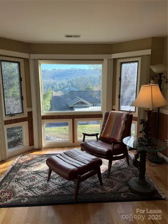 a living room with furniture water view and large windows