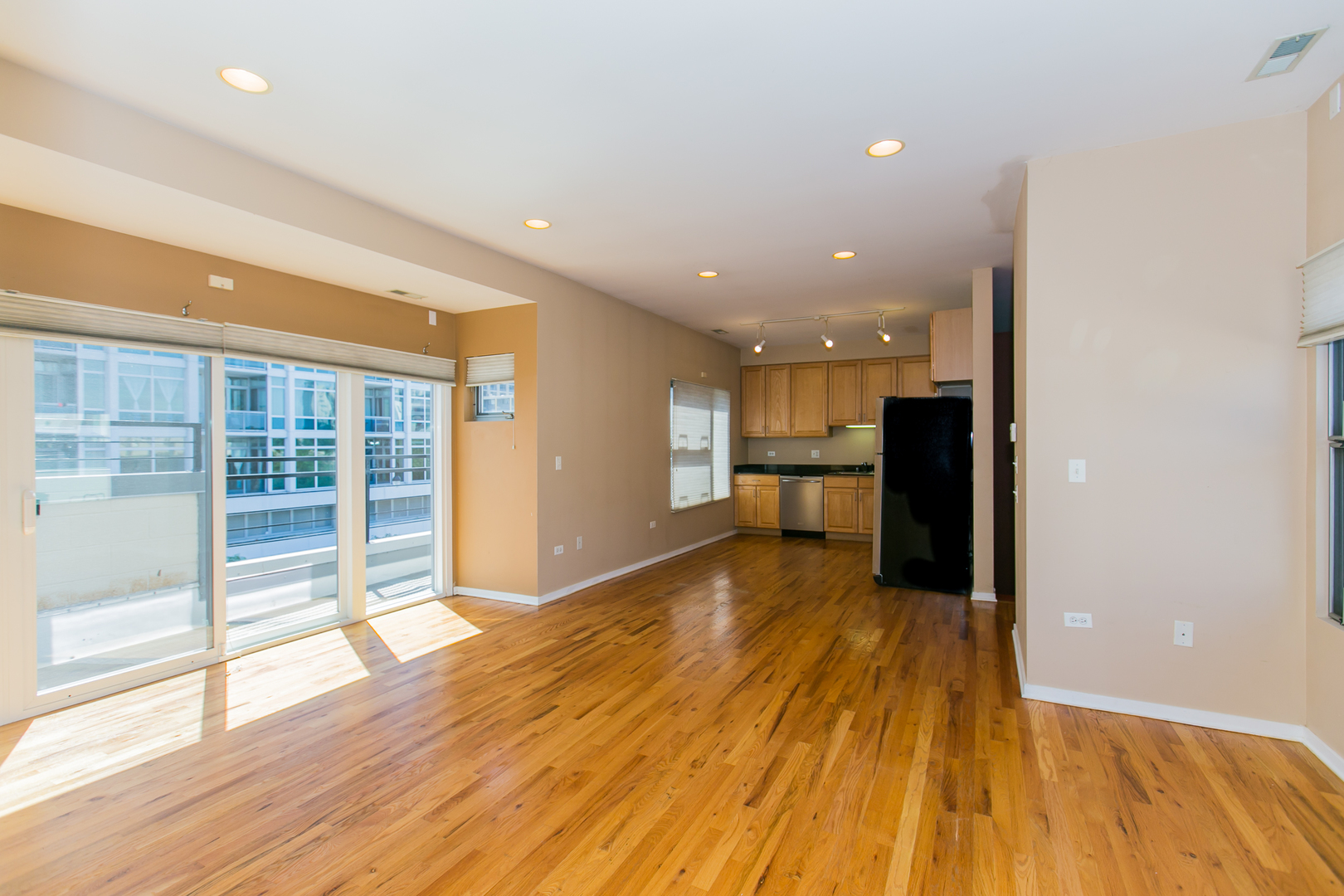 1808 South Michigan Avenue, Unit 38 Chicago, IL 60616 - Photo 9 of 18 a view of an empty room with wooden floor and a kitchen