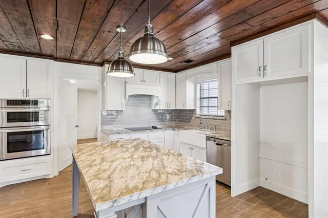 a kitchen with stainless steel appliances granite countertop a sink stove and refrigerator