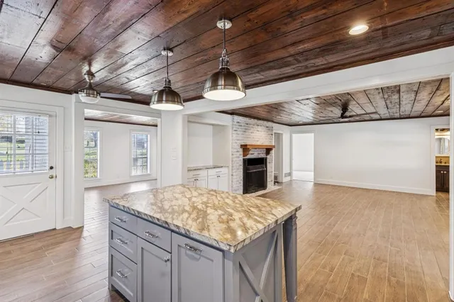 a kitchen with kitchen island granite countertop a stove and a wooden floors