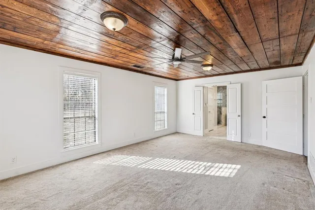 a bathroom with a granite countertop sink a toilet a mirror and window