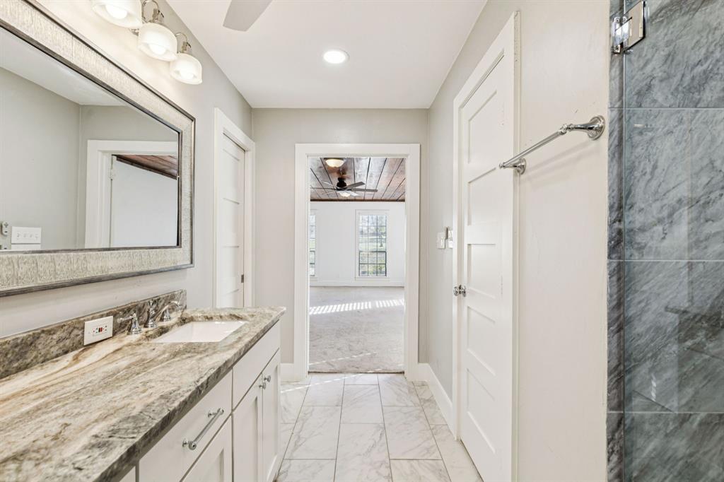 209 McMillen Road Lucas, TX 75002 - Photo 20 of 38 a bathroom with a granite countertop sink a mirror and a shower