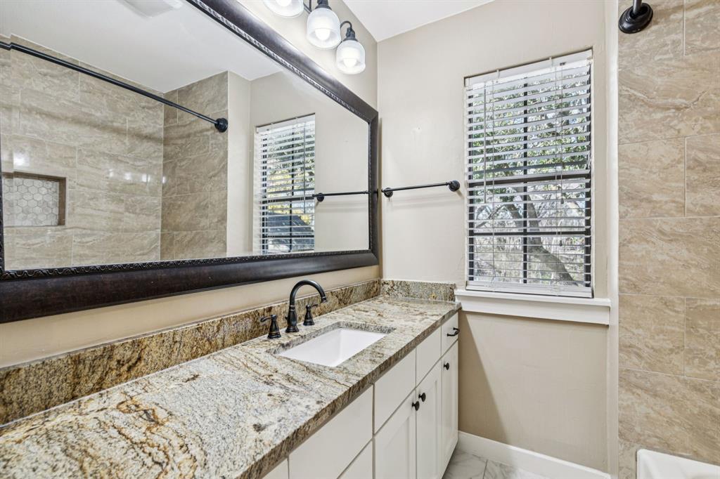 209 McMillen Road Lucas, TX 75002 - Photo 27 of 38 a bathroom with a granite countertop sink a mirror and a shower
