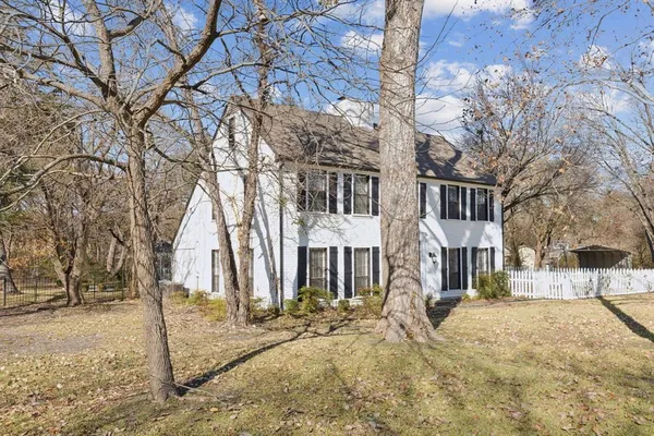 a front view of a house with a yard covered in snow
