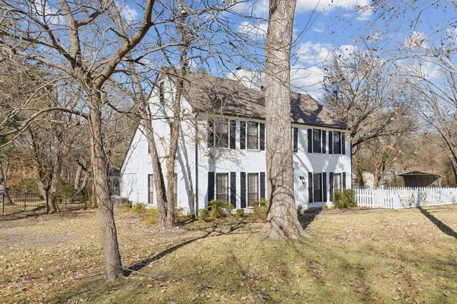 a front view of a house with a yard covered in snow