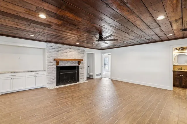 a view of an empty room with a fireplace and a window