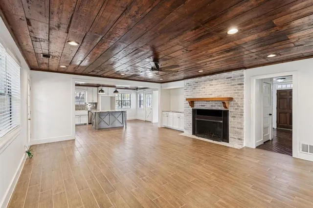 a view of empty room with wooden floor and fireplace