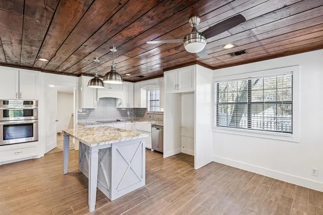 a kitchen with a stove and wooden floor