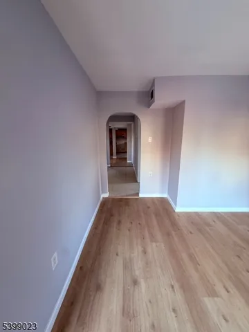 a view of empty room with wooden floor and fireplace