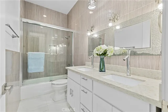 a bathroom with a double vanity sink toilet and shower