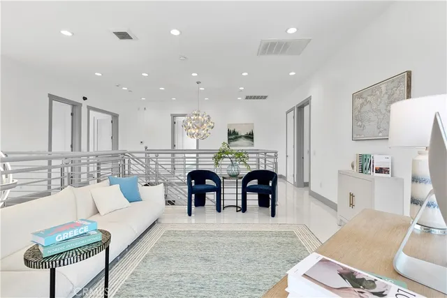 a living room with stainless steel appliances furniture a rug and a kitchen