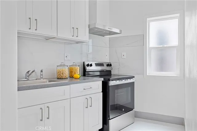a kitchen with white cabinets and a sink