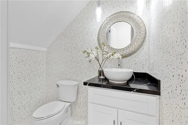 a bathroom with a toilet a sink and a mirror