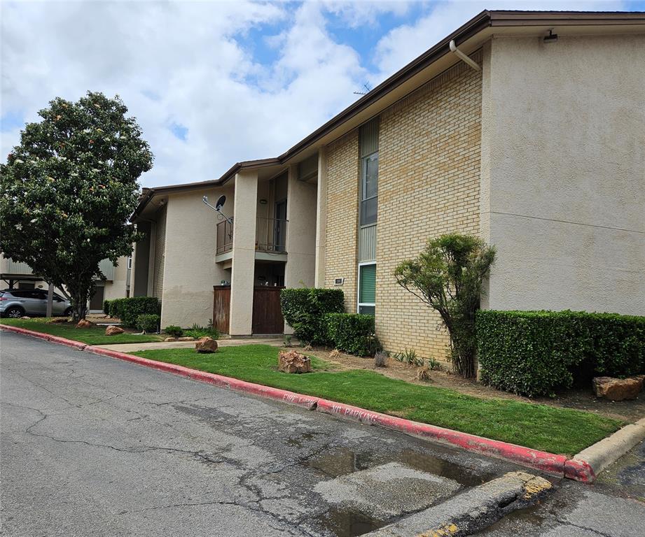 12816 Midway Road, Unit 1067 Dallas, TX 75244 - Photo 2 of 19 featuring a balcony, manicured shrubs, mature trees, and a grass lawn