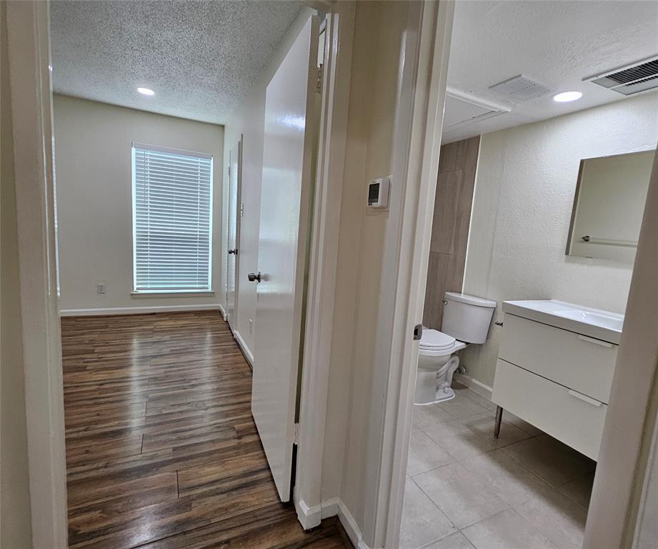 12816 Midway Road, Unit 1067 Dallas, TX 75244 - Photo 7 of 19 Bedroom featuring wood-finish flooring, recessed lighting, and a window with blinds
