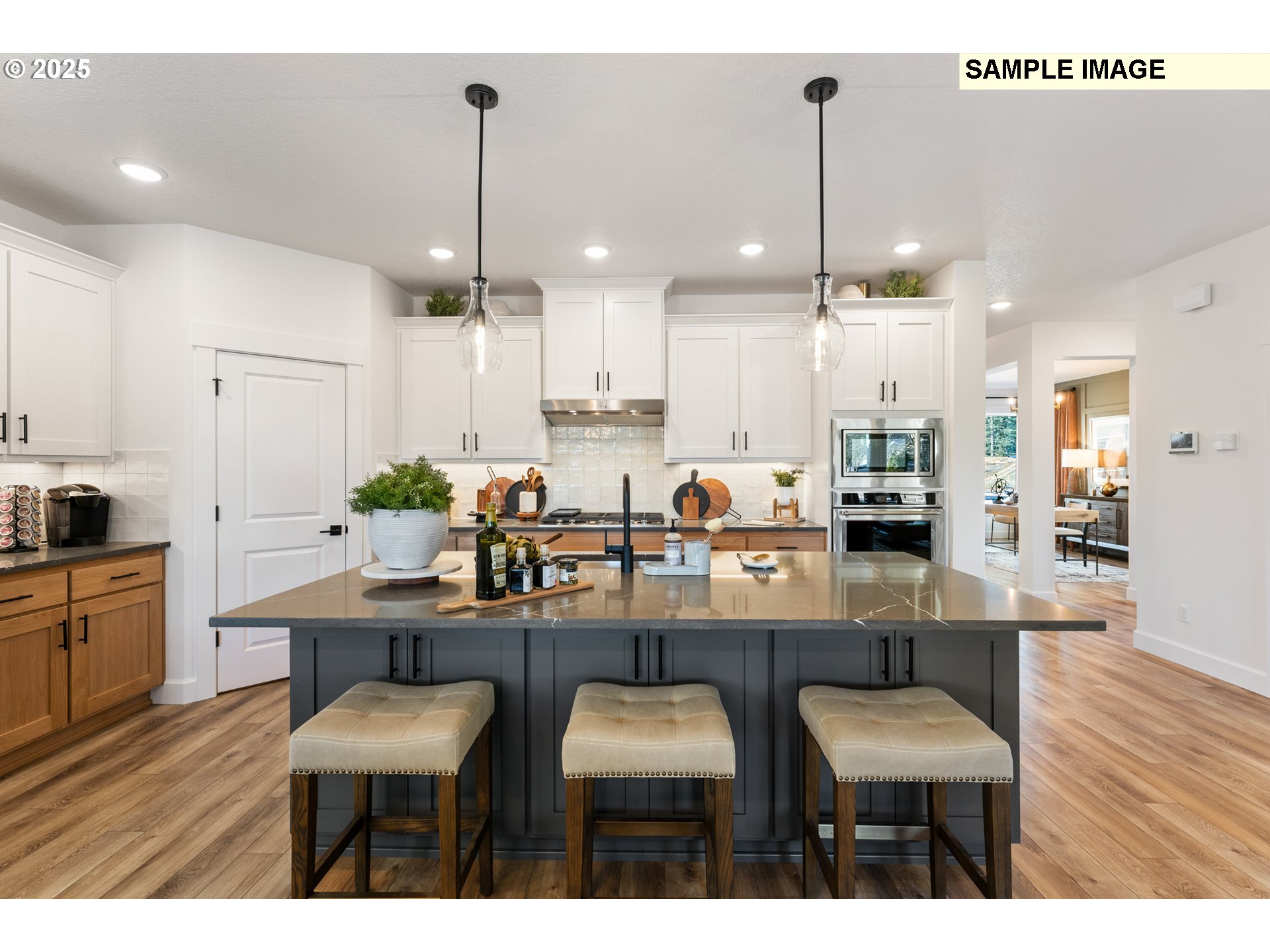 16502 Southwest Deer Terrace Durham, OR 97224 - Photo 13 of 42 a kitchen with stainless steel appliances kitchen island granite countertop a dining table chairs and white cabinets