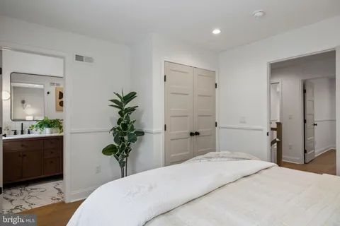 a bedroom with a bed and a potted plant